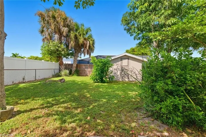 View of fenced backyard with 2 storage sheds
