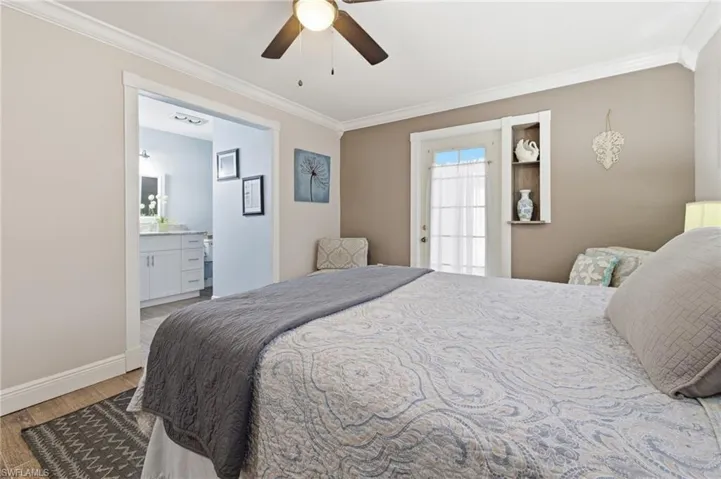 Bedroom with ornamental molding, wood-like tile finished floors, a ceiling fan, and ensuite bathroom