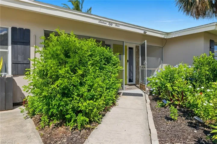 Property entrance with stucco siding and a sunroom
