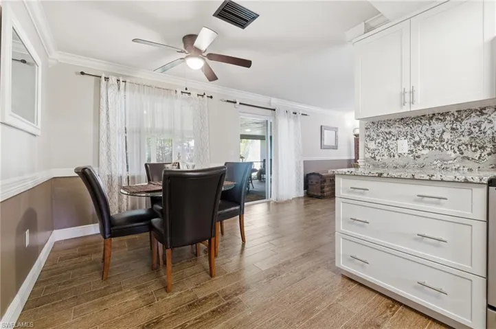 Dining room with ornamental molding,Wood-like tile floors, and ceiling fan
