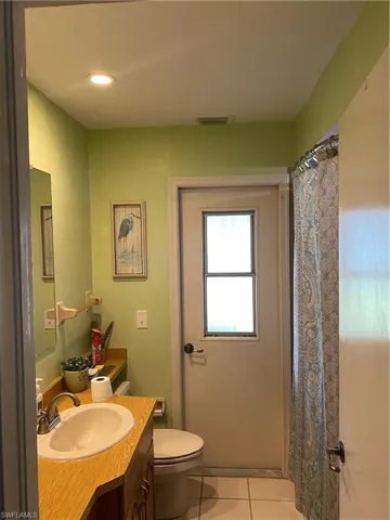 Bathroom with tile patterned floors, vanity, and a shower with shower curtain