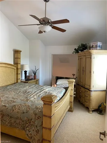 Bedroom with light carpet, lofted ceiling, and ceiling fan