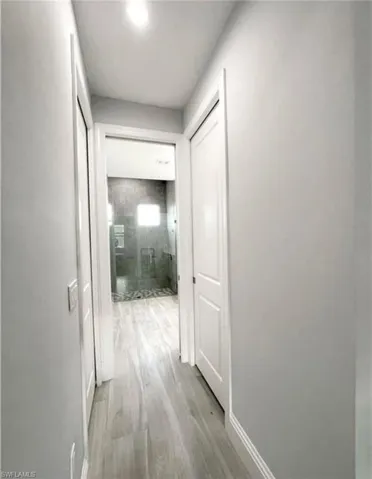 Hallway featuring baseboards and light wood finished floors