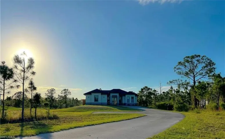 View of front facade featuring aphalt driveway and a front yard