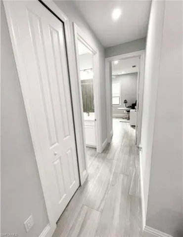Hall with baseboards and wood tiled floor