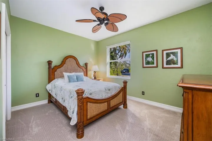 Guest bedroom featuring designer tropical furnishings, light colored carpet and ceiling fan with separation from the Master bedroom give privacy to all to enjoy time together.