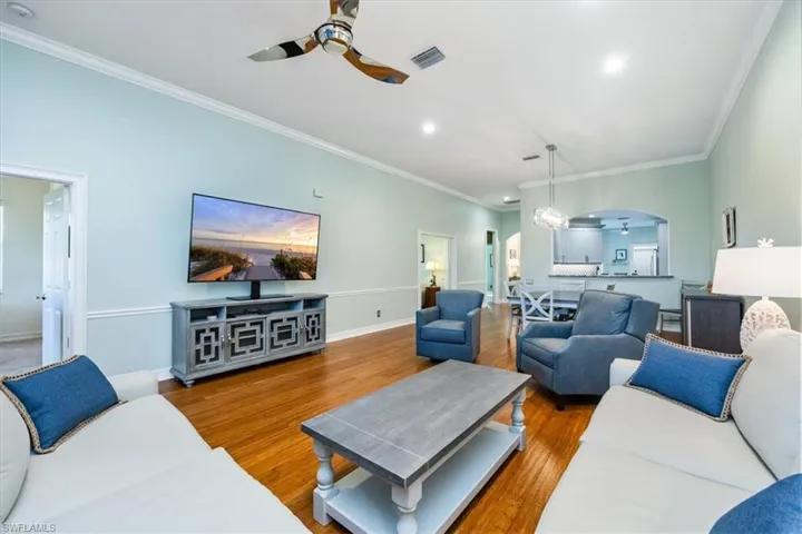 Living room lives like a great roomThe living room functions as a great room with a formal dining area, featuring open windows that lead to a screened lanai overlooking the preserve. with formal dining, open windows to screened lanai overlooking the preserve.