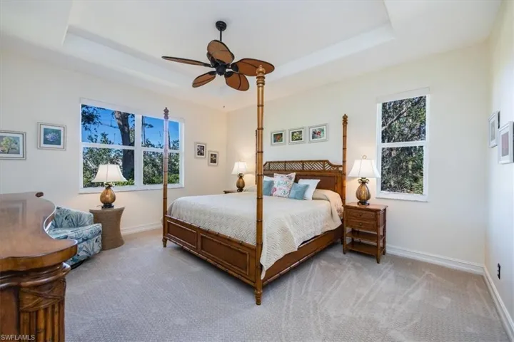 The master bedroom features walk-in closets, plantation shutters, a sliding door leading to the lanai, and tray ceilings.