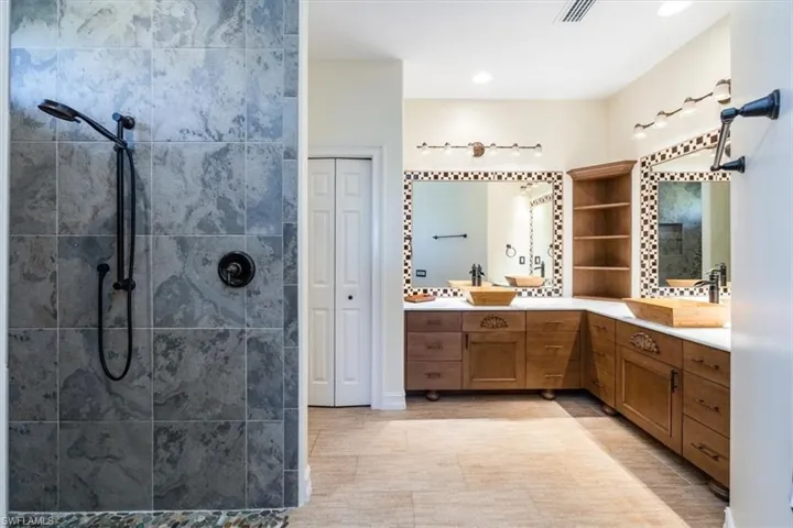 Bathroom featuring dual vanities, teak wood and stone walk in shower is a resptie waiting for you!