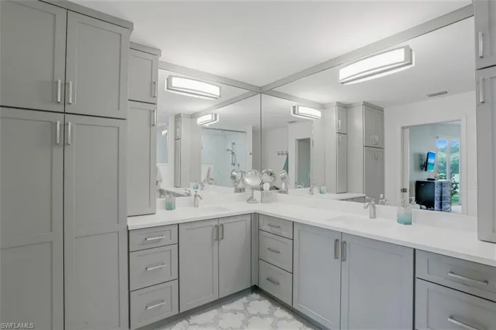 Full bathroom with double vanity, a shower, and a wall unit AC
