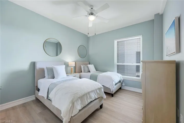 Bedroom featuring baseboards, light wood-style floors, and a ceiling fan