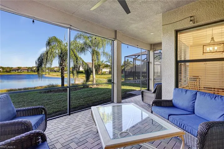 Sunroom / solarium featuring ceiling fan and a water view