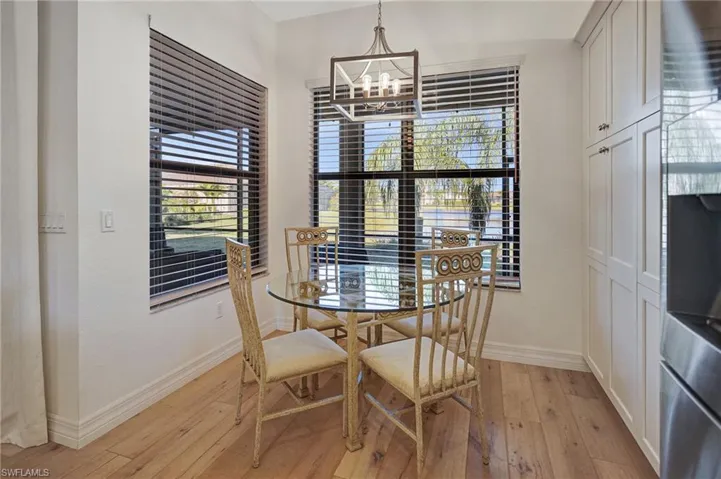 Dining room featuring light wood-type flooring, baseboards, and an inviting chandelier