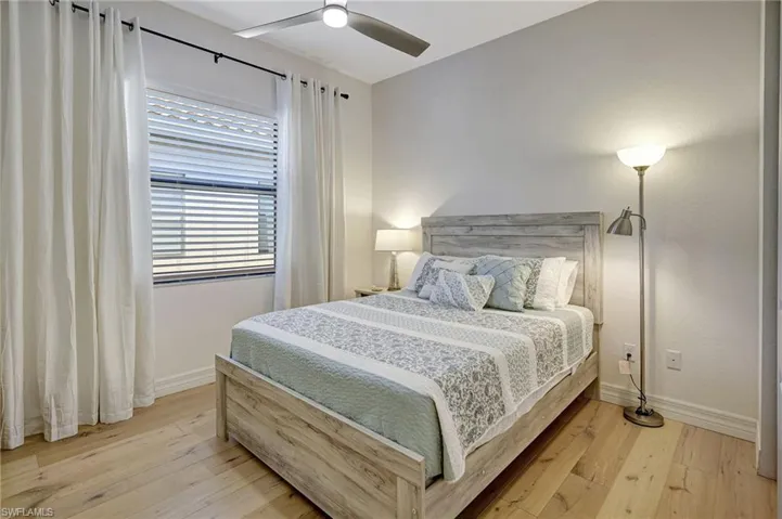 Bedroom with baseboards, ceiling fan, and hardwood / wood-style floors