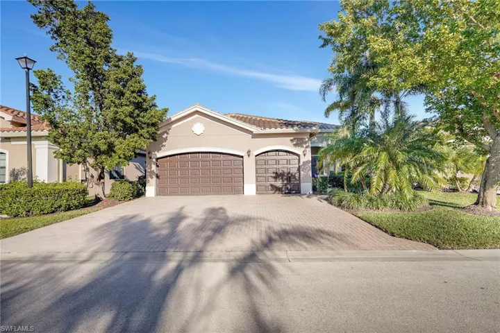 Mediterranean / spanish home featuring decorative driveway, an attached garage, a tile roof, and stucco siding