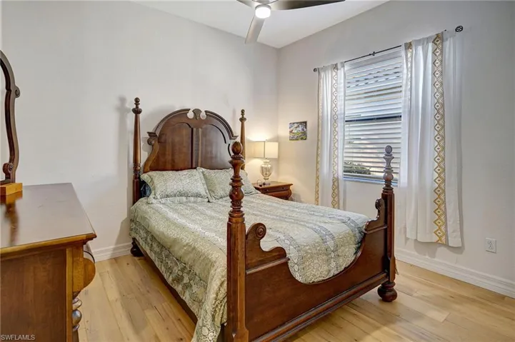 Bedroom featuring a ceiling fan, baseboards, and light wood finished floors