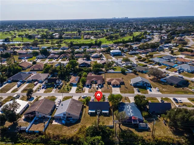 Aerial view of property and surrounding area with nearby suburban area