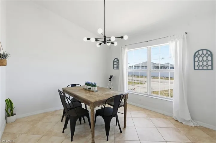 Dining space featuring vaulted ceiling, a chandelier, and light tile patterned floors