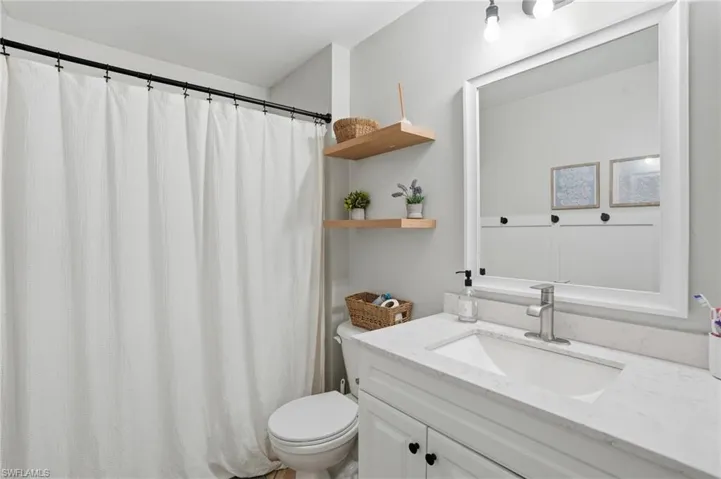 Full bathroom featuring curtained shower and vanity