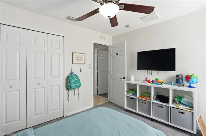 Carpeted bedroom featuring a closet and a ceiling fan
