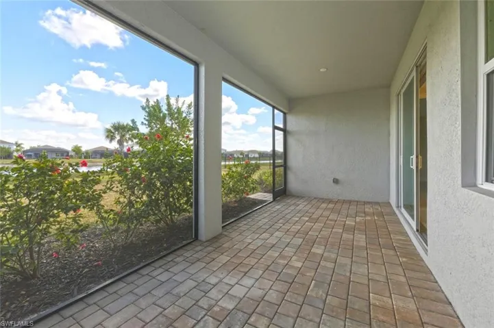 Unfurnished sunroom featuring a textured wall, brick flooring, and recessed lighting