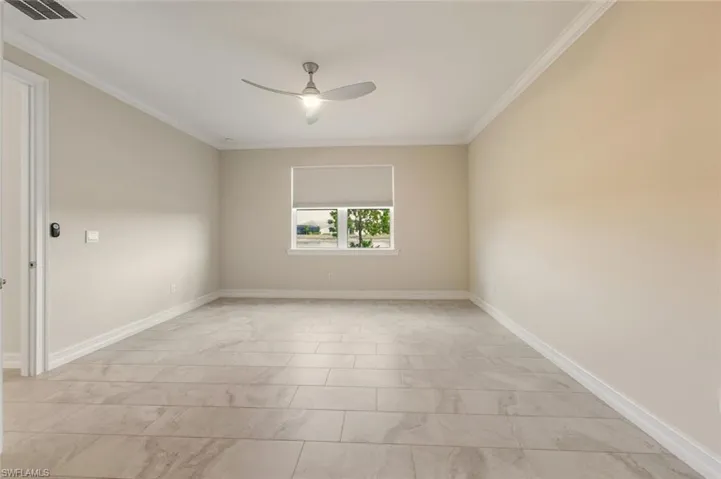 Empty room featuring ornamental molding and ceiling fan