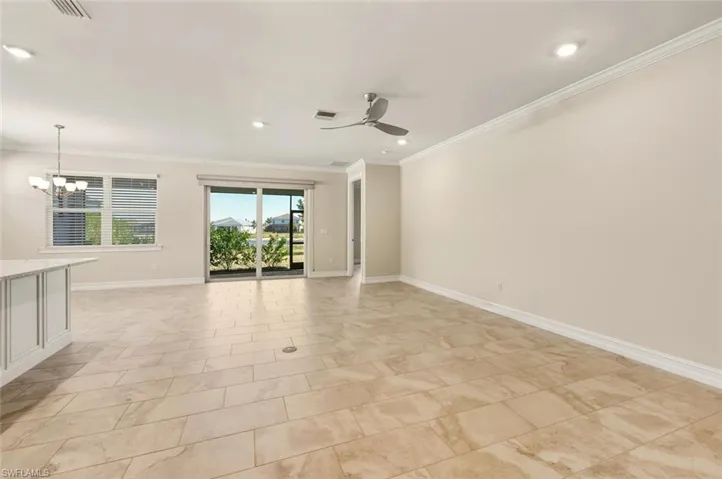 Spare room with crown molding, hanging lights, and ceiling fan