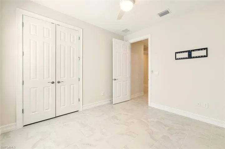 Unfurnished bedroom with a ceiling fan and a closet