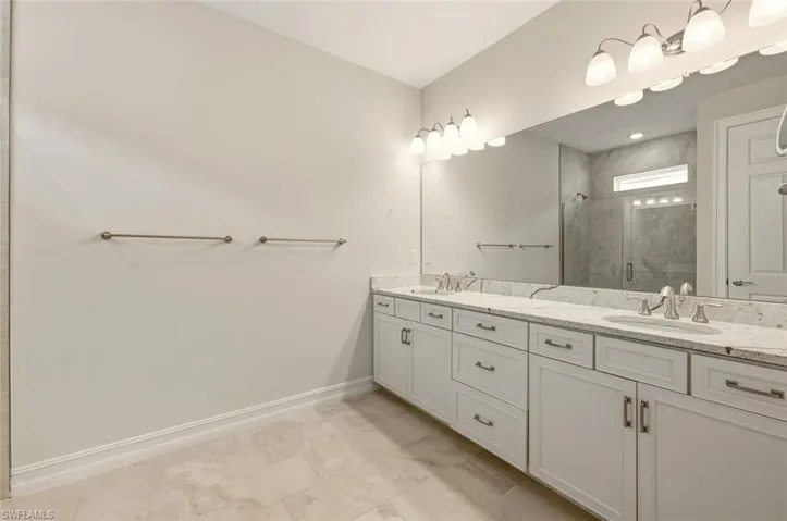 Bathroom featuring double vanity and a stall shower