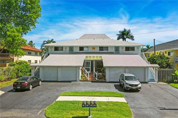 Multi-unit property with a light-colored exterior and a prominent central entrance