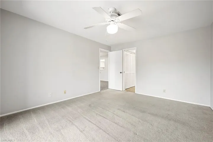 Spacious room featuring light gray carpeting and freshly painted walls