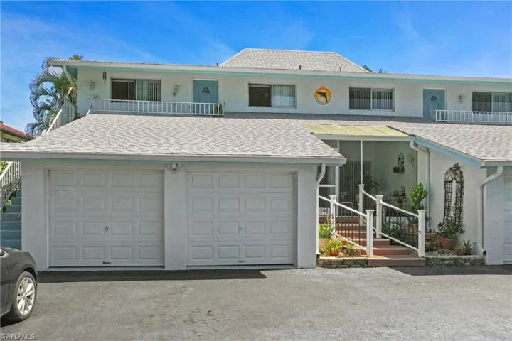 Multi-level exterior with a light-colored shingled roof, dual garage doors, and a screened-in porch with steps