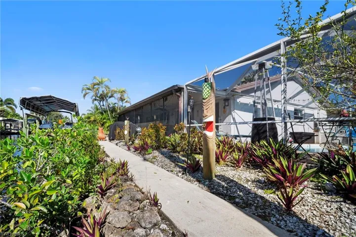Concrete pathway surrounded by lush tropical landscaping and a rock garden
