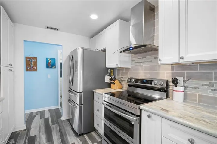 Kitchen featuring stainless steel appliances, white cabinetry, and light-toned countertops