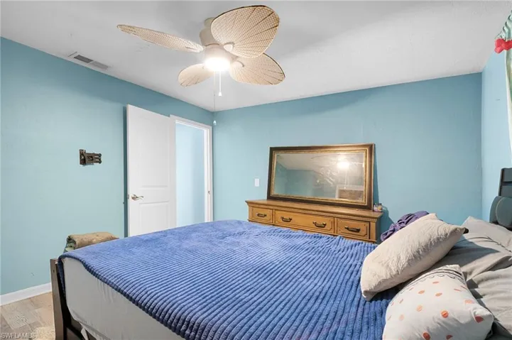 Bedroom featuring a ceiling fan, light blue walls, and wood-finish flooring
