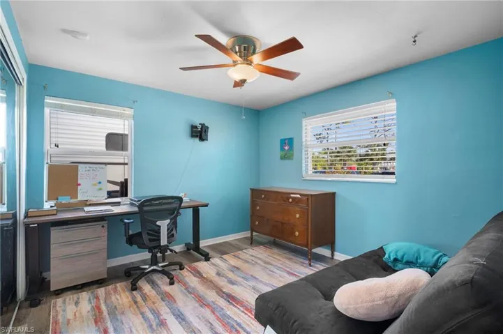 Bright room with wood-finish flooring and a ceiling fan with integrated lighting