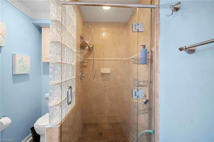 Glass-enclosed shower with tile surround and floor, featuring a multi-function showerhead
