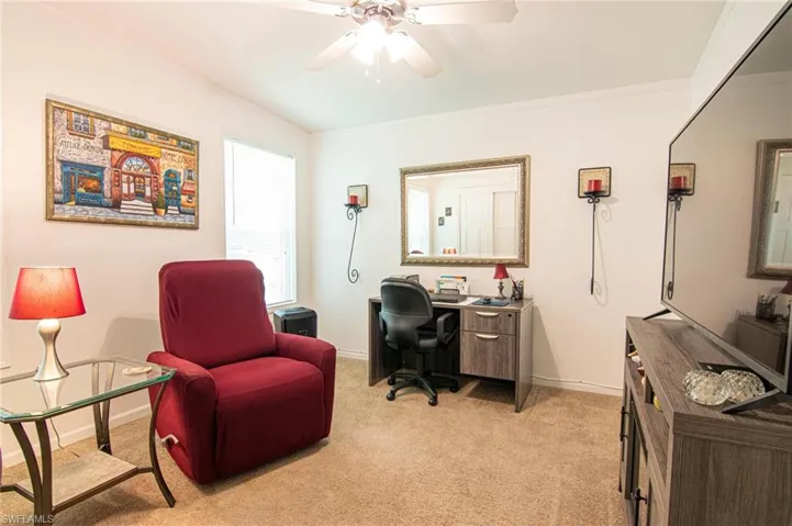 Office space with light colored carpet, crown molding, and ceiling fan