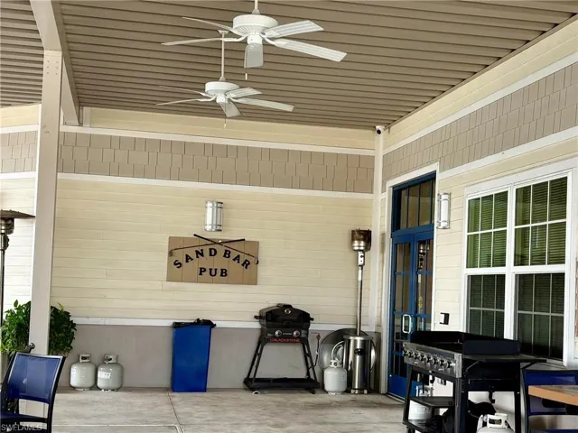 View of patio with grilling area and a ceiling fan