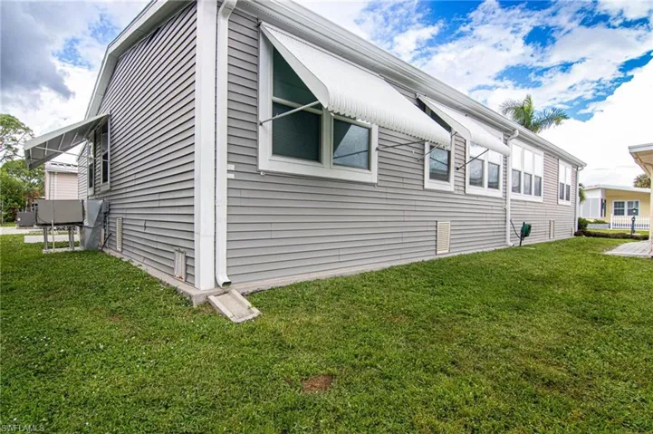 View of side of home featuring a yard