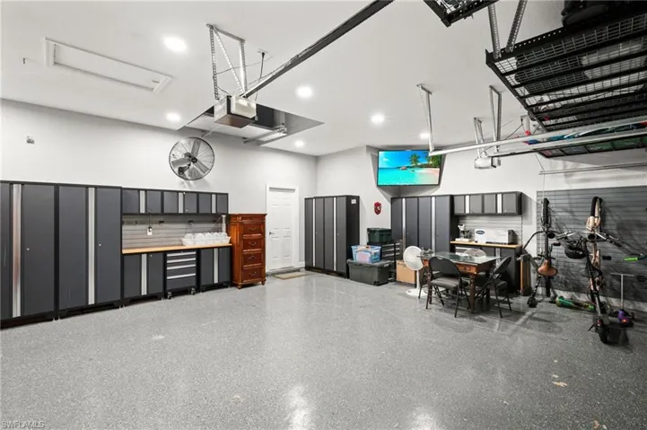 3 car garage with custom cabinets & storage, epoxy floors
