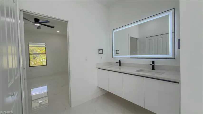 Full bath with light marble finish flooring, double vanity, ceiling fan, and recessed lighting