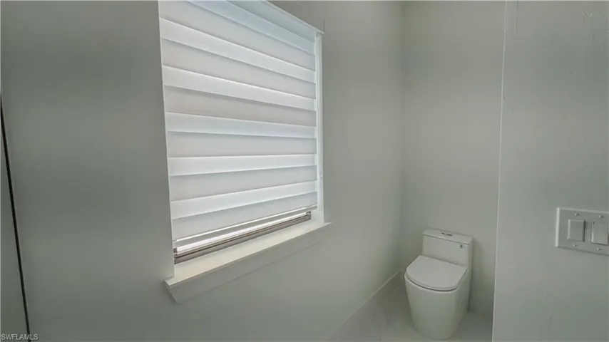 Bathroom with marble look tiles and baseboards