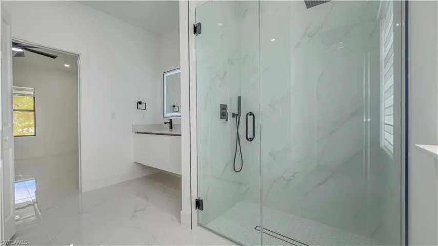 Full bathroom featuring light marble finish flooring, a marble finish shower, vanity, and recessed lighting