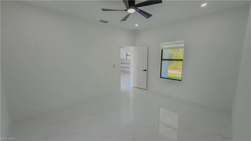 Empty room featuring light marble finish flooring, recessed lighting, and ceiling fan