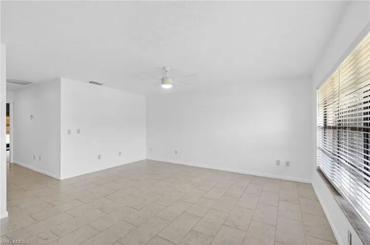 Empty room featuring ceiling fan and baseboards