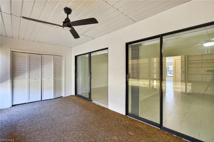 Unfurnished bedroom with a closet, ceiling fan, carpet flooring, and a textured wall
