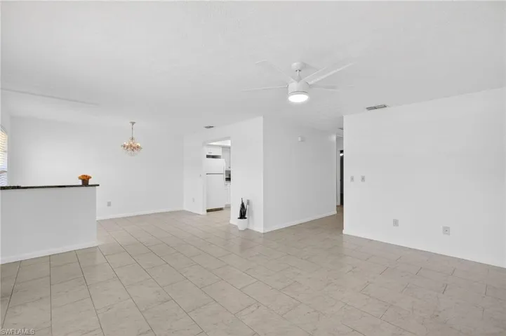 Unfurnished room with a ceiling fan and suspended lighting