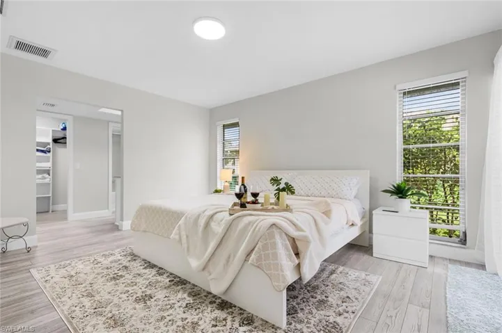 Light-toned wood-finish flooring, recessed lighting, and a spacious walk-in closet with built-in shelving