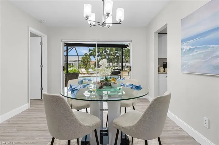 Dining area with wood-finish flooring and a contemporary chandelier